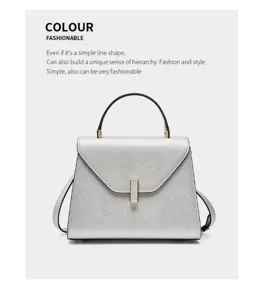 Detailed view of the luxury silver leather handbag featuring unique vertical metal clasp and handle.