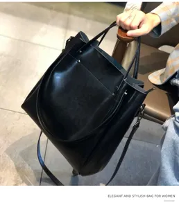 Vista detallada del elegante bolso tote de cuero negro, mostrando textura y correa.