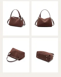 Brown suede shoulder bag detail showing unique metal ring hardware and bottom structural rivets.