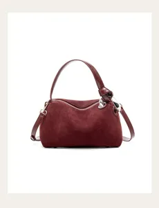 Close-up detail view of the premium maroon suede leather handbag showing zipper and hardware.