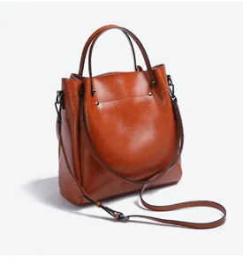 Detalle de bolso bandolera de piel marrón, cuero genuino de alta calidad con herrajes.