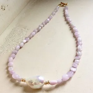 Dettaglio della collana di perle in pietra naturale con grande ciondolo barocco.