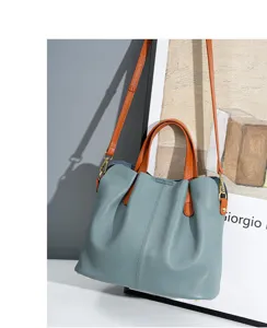 Genuine leather contrast tote bag detail view, slouchy design with brown handles and strap.