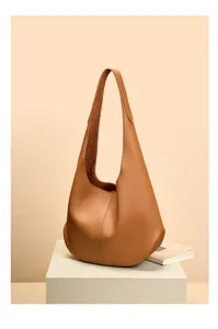 Detailed view of brown leather hobo shoulder bag, showing premium pebbled texture and shape.