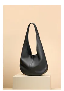 Detailed view of the black leather hobo shoulder bag, showcasing smooth texture and curves.