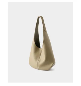 Detail shot of minimalist leather hobo shoulder bag showing fine texture and sleek curved silhouette.