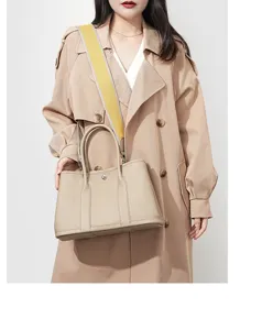 Beige leather tote bag detail view, casual commuting handbag with wide strap and top handles.