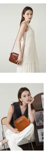 Detailed view of the elegant brown leather crossbody bag worn by a model in a studio.