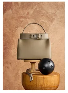 Detailed view of luxury leather top-handle bag with pyramid stud strap in stylish aesthetic.