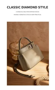 Elegant khaki leather shoulder and crossbody bag with top handle and chic metal lock hardware.