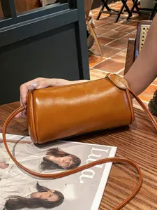 Fashionable brown cylinder leather shoulder bag for women, elegant daily crossbody design.