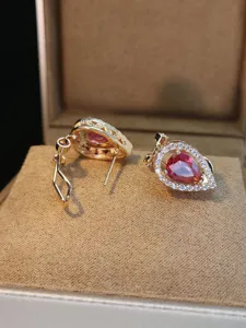 Raffinati orecchini a goccia con pietre rosa brillanti e un design dorato elegante.