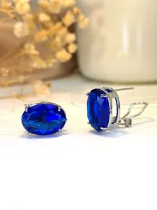 Primo piano dettagliato in metallo di eleganti orecchini con pietra blu ovale argentata.
