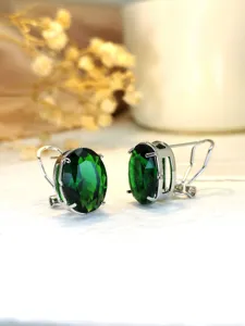 Dettaglio di orecchini eleganti con pietra verde ovale e montatura in argento brillante.