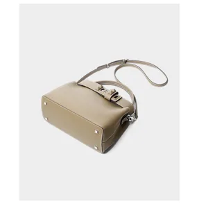 Detailed view of the elegant grey leather shoulder bag with chic stud details and strap.