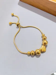 Elegante bracciale con perle e cuore in acciaio inossidabile dorato, dettaglio lucido.