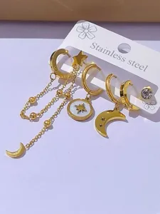 Dettaglio raffinato di orecchini pendenti dorati con motivi di luna, stella e nappe eleganti.