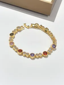 Vista dettagliata di un bracciale tennis dorato con zirconi multicolori splendenti.