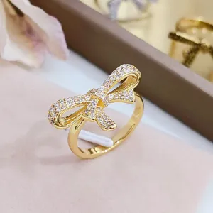 Vue détaillée d'une bague nœud dorée élégante étincelante avec des pierres de zircone.