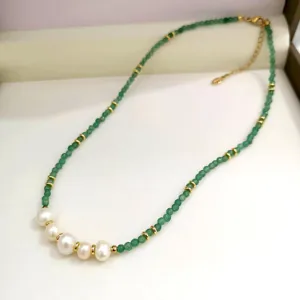 Deliziosa collana di perle verdi e bianche con distanziatori dorati in dettaglio.