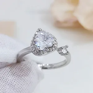 Primo piano dettagliato di un anello aperto a cuore in zircone cubico micro-pavé, elegante.