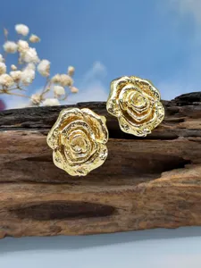 Orecchini vintage a rosa dorata su legno rustico primo piano con sfondo naturale.