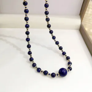 Primo piano di collana di perle in lapislazzuli naturale con distanziatori dorati.