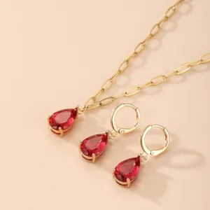 Set di gioielli alla moda con collana dorata e orecchini in zircone rosso a goccia.