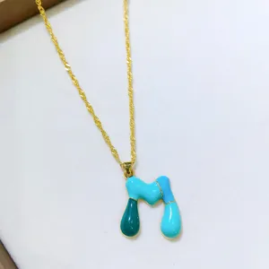 Primo piano di una collana con ciondolo alfabeto colorato con dettagli in smalto raffinati.