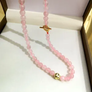 Dettaglio in primo piano della collana di perline in quarzo rosa con chiusura e ciondolo.