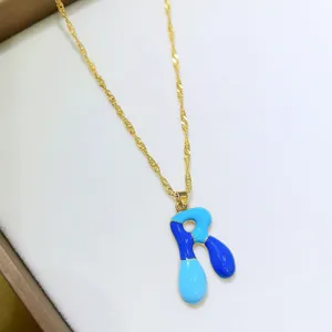 Squisita collana con lettere smaltate e vivaci toni blu con catena dorata lucida.