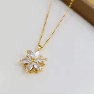 Primo piano del ciondolo per collana con fiore in zircone dorato con scintillanti cristalli bianchi.