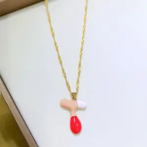 Primo piano del ciondolo per collana con lettera dopamina colorata con catena oro.