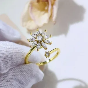 Vista dettagliata dell'elegante anello floreale rotante con zirconi scintillanti e finitura oro.