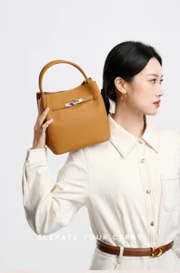 Detailed view of the luxury genuine leather handbag with elegant turn-lock closure and texture.