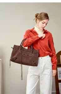 Brown suede motorcycle shoulder bag for women, stylish vintage handbag with metal studs and zipper.