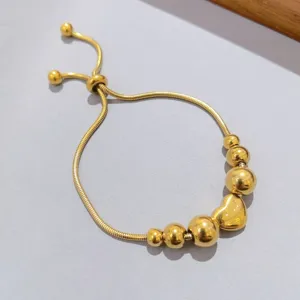 Bracciale scorrevole a catena di serpente dorato con perle tonde graduate e ciondolo cuore.