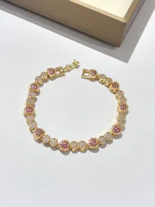Elegante bracciale tennis dorato con zirconi a cuore rosa e bianchi scintillanti.