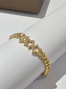 Bracciale a catena dorata con maglie a stella pavimentate di zirconi colorati.
