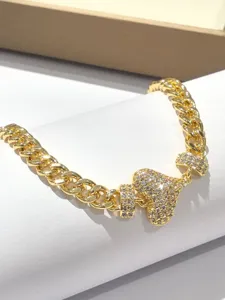 Bracciale catena cubana dorato con un ciondolo a cuore scintillante da donna.