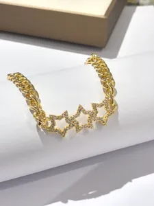 Dettaglio bracciale dorato con charm a stella pavé di luminosi zirconi lucidi.