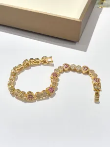 Elegante bracciale con maglie a cuore dorate e zirconi rosa e bianchi da donna.