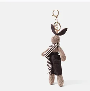 Vue détaillée du mini porte-clés lapin en peluche mignon avec une écharpe rayée.