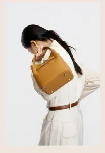 Elegant genuine leather bucket bag for women, stylish minimalist handbag with metal lock.