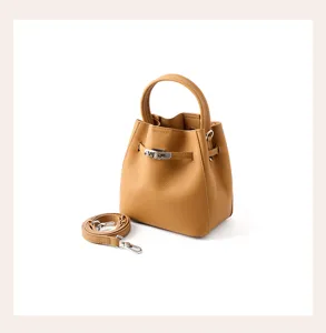 Close-up of premium leather bucket bag with metallic turn-lock closure and shoulder strap.