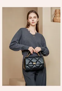 Klassische schwarze gesteppte Kettentasche mit eleganten goldfarbenen Beschlägen und Drehverschluss.