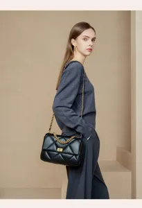 Nahaufnahme der schwarzen gesteppten Schultertasche mit goldener Kette und edlem Verschluss.