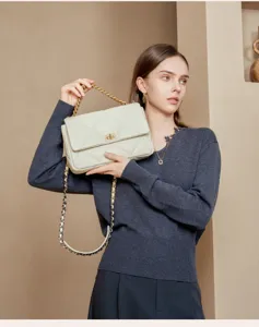 Elegante gesteppte Ketten-Umhängetasche Detail aus weißem Leder mit goldener Hardware.