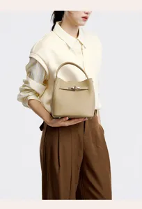 Elegant genuine leather bucket handbag with top handle and metal lock closure for women commute.