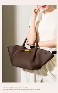 Detailed view of brown leather tote bag with folding fan design and gold hardware.